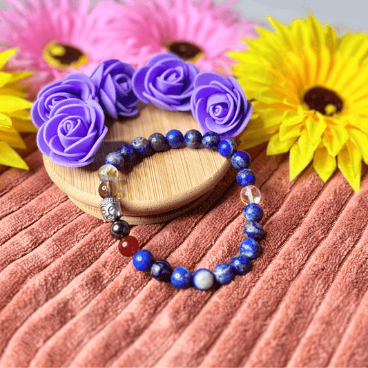 Focus Bracelet with colorful stones on a wooden coaster surrounded by flowers
