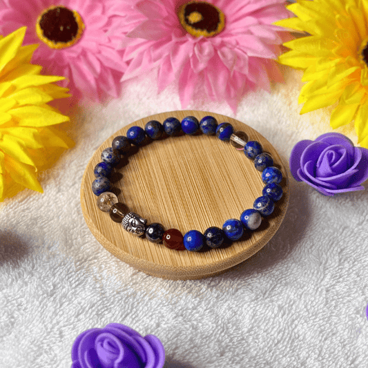 Beaded bracelet on a wooden coaster with flowers in the background