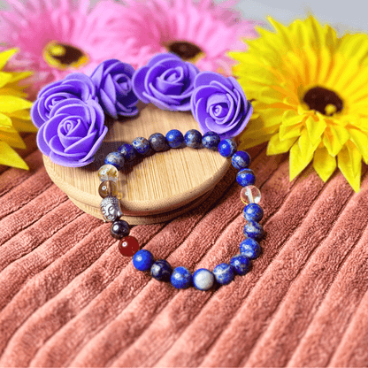 Focus Bracelet with colorful stones on a wooden coaster surrounded by flowers