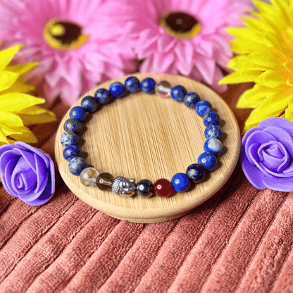 Beaded bracelet on a wooden coaster with flowers in the background